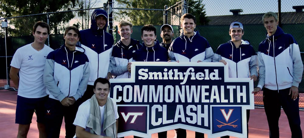 The Cavaliers pose with the Commonwealth Clash sign after defeating the Hokies 6-1 Wednesday.&nbsp;