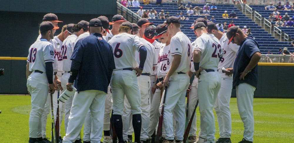 The Cavaliers huddle at the College World Series in 2023, ready for battle.