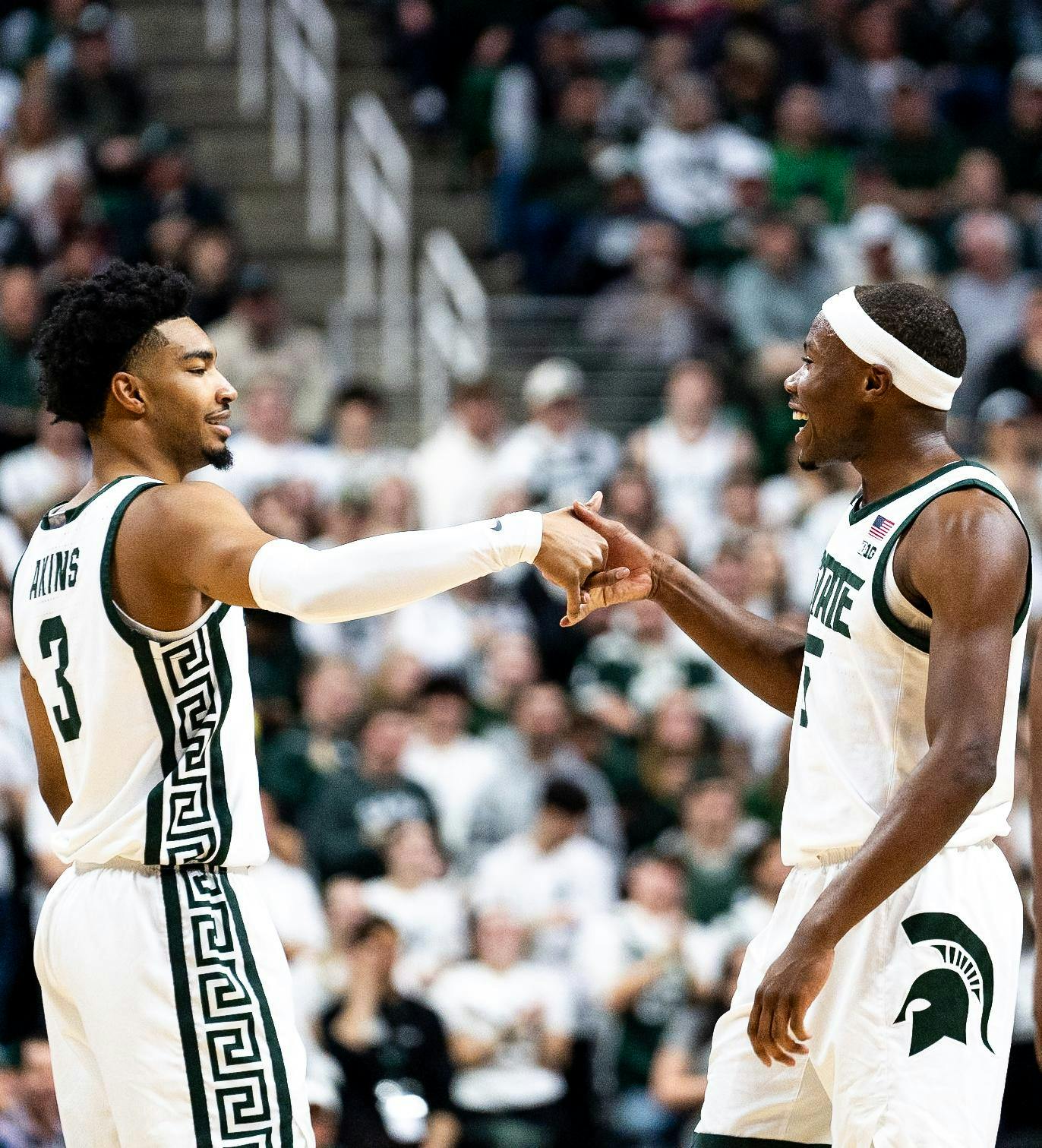 Michigan State junior guard Tre Holloman (5) and Michigan State senior guard Jaden Akins (3) celebrate with a handshake at the Breslin Center on Jan. 28, 2025.